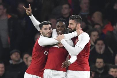 Arsenals English striker Danny Welbeck (C) celebrates scoring the opening goal with team-mates Arsenals German-born Bosnian defender Sead Kolasinac (L) and Arsenals French striker Olivier Giroud (R) during the English League Cup quarter-final football match between Arsenal and West Ham United at the Emirates Stadium in London on December 19, 2017.  / AFP PHOTO / Ben STANSALL / RESTRICTED TO EDITORIAL USE. No use with unauthorized audio, video, data, fixture lists, club/league logos or live services. Online in-match use limited to 75 images, no video emulation. No use in betting, games or single club/league/player publications.  / 