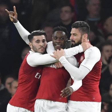 Arsenals English striker Danny Welbeck (C) celebrates scoring the opening goal with team-mates Arsenals German-born Bosnian defender Sead Kolasinac (L) and Arsenals French striker Olivier Giroud (R) during the English League Cup quarter-final football match between Arsenal and West Ham United at the Emirates Stadium in London on December 19, 2017.  / AFP PHOTO / Ben STANSALL / RESTRICTED TO EDITORIAL USE. No use with unauthorized audio, video, data, fixture lists, club/league logos or live services. Online in-match use limited to 75 images, no video emulation. No use in betting, games or single club/league/player publications.  / 