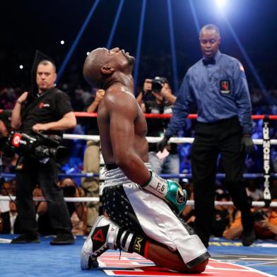 LAS VEGAS, NV - SEPTEMBER 12: Floyd Mayweather Jr. kneels on the mat after winning his WBC/WBA welterweight title fight against Andre Berto at MGM Grand Garden Arena on September 12, 2015 in Las Vegas, Nevada. Mayweather won the fight by unanimous decision.   Ezra Shaw/Getty Images/AFP
