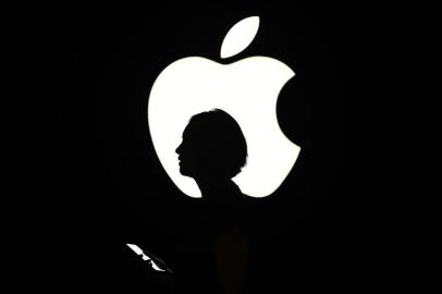 576709901A reporter walks by an Apple logo during a media event in San Francisco, California on September 9, 2015. Apple unveiled its iPad Pro, saying the large-screen tablet has the power and capabilities to replace a laptop computer.    AFP PHOTO/JOSH EDELSONEditoria: FINLocal: San FranciscoIndexador: Josh EdelsonSecao: computing and information technoFonte: AFPFotógrafo: STR