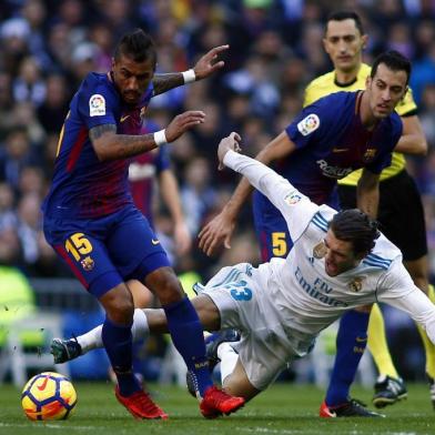 Barcelona's Brazilian midfielder Paulinho (L) vies with Real Madrid's Croatian midfielder Mateo Kovacic during the Spanish League "Clasico" football match Real Madrid CF vs FC Barcelona at the Santiago Bernabeu stadium in Madrid on December 23, 2017.  / AFP PHOTO / OSCAR DEL POZO