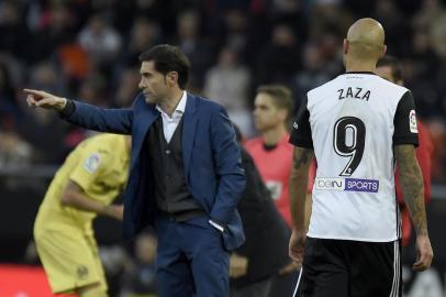 Valencias coach Marcelino (L) gives instructions to his players during the Spanish league football match Valencia CF and Villarreal CF at Mestalla stadium in Valencia on December 23, 2017. / AFP PHOTO / JOSE JORDAN