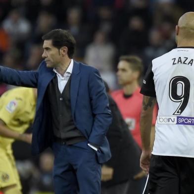 Valencias coach Marcelino (L) gives instructions to his players during the Spanish league football match Valencia CF and Villarreal CF at Mestalla stadium in Valencia on December 23, 2017. / AFP PHOTO / JOSE JORDAN