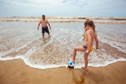  CAPÃO DA CANOA, RS, BRASIL, 25/12/2017 : Ambiental de praia no dia de Natal. Na foto Ranier Bertagnolli, 53 anos, industriário  e a filha Fernanda Bertagnolli, oito anos    (Omar Freitas/Agência RBS)Indexador: Omar Freitas