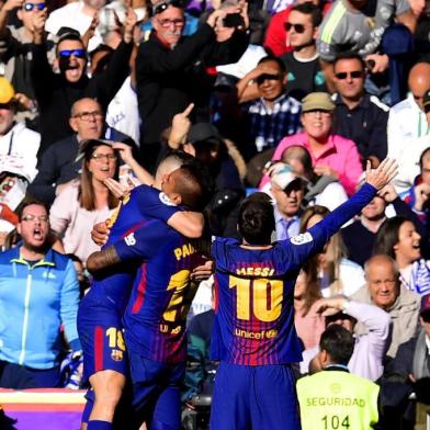 Barcelonas Argentinian forward Lionel Messi (R) celebrates after scoring during the Spanish League Clasico football match Real Madrid CF vs FC Barcelona at the Santiago Bernabeu stadium in Madrid on December 23, 2017.  / AFP PHOTO / JAVIER SORIANO