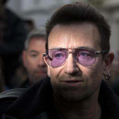 U2 frontman Bono arrives at a west London studio to record the new Band Aid 30 single on November 15, 2014. Bob Geldof, One Direction, Bono and some 30 other stars gathered in a studio in London on Saturday to record a 30th anniversary version of the Band Aid charity single to raise money to fight Ebola. Led Zeppelin's Robert Plant, Coldplay's Chris Martin and Sinead O'Connor were also among the rockers brought together by Geldof to sing the fourth version of "Do They Know It's Christmas?" Musicians began arriving in the early morning and were expected to record all day and into the night before the single is aired for the first time on Sunday and then officially released on Monday. AFP PHOTO / ANDREW COWIE