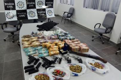 Uma operação da Polícia Civil resultou na apreensão de grande quantia em dinheiro, cocaína e armas em Caxias do Sul, por volta das 17h desta quinta-feira. Duas pessoas foram presas. A ação na Rua dos Jasmins, no bairro Charqueadas, foi coordenada pela Delegacia de Furtos, Roubos, Entorpecentes e Capturas (Defrec) e teve apoio da Delegacia de Homicídios. Conforme o titular da Defrec, Adriano Linhares, a operação é um combate a uma facção de criminosos na cidade. O total de dinheiro apreendido ainda não foi contabilizado. Os agentes tiveram que usar caixas para transportar o dinheiro.