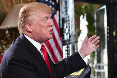  US President Donald J. Trump gestures as he participates in a video teleconference call with military members on Christmas Eve in Palm Beach, Florida on December 24, 2017.  / AFP PHOTO / Nicholas KammEditoria: POLLocal: Palm BeachIndexador: NICHOLAS KAMMSecao: politics (general)Fonte: AFPFotógrafo: STF