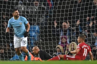 Manchester Citys Argentinian striker Sergio Aguero scores their third goal past Watfords Brazilian goalkeeper Heurelho Gomes (2R) during the English Premier League football match between Manchester City and Watford at the Etihad Stadium in Manchester, north west England, on January 2, 2018. / AFP PHOTO / Paul ELLIS / RESTRICTED TO EDITORIAL USE. No use with unauthorized audio, video, data, fixture lists, club/league logos or live services. Online in-match use limited to 75 images, no video emulation. No use in betting, games or single club/league/player publications.  / 