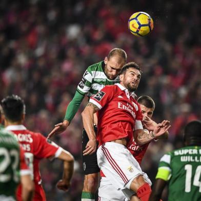 Sportings Dutch forward Bas Dost (L) heads the ball with Benficas Brazilian defender Jardel during the Portuguese league football match SL Benfica vs Sporting CP at the Luz stadium in Lisbon on January 3, 2018. / AFP PHOTO / PATRICIA DE MELO MOREIRA