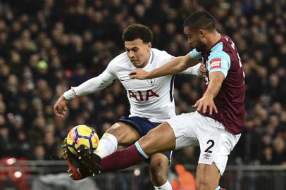 West Ham Uniteds New Zealand defender Winston Reid (R) reaches the ball ahead of Tottenham Hotspurs English midfielder Dele Alli (L) to clear during the English Premier League football match between Tottenham Hotspur and West Ham United at Wembley Stadium in London, on January 4, 2018. / AFP PHOTO / Glyn KIRK / RESTRICTED TO EDITORIAL USE. No use with unauthorized audio, video, data, fixture lists, club/league logos or live services. Online in-match use limited to 75 images, no video emulation. No use in betting, games or single club/league/player publications.  / 