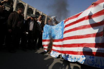  Iranian pro-government demonstrators set a makeshift US flag on fire during a march after the weekly Muslim Friday prayers in Tehran on January 5, 2018.New pro-regime protests were held in Iran, in reaction to the protests against the government and the cost of living.  / AFP PHOTO / ATTA KENAREEditoria: POLLocal: TehranIndexador: ATTA KENARESecao: politics (general)Fonte: AFPFotógrafo: STF
