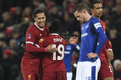 Liverpools Dutch defender Virgil van Dijk (L) hugs Liverpools Senegalese midfielder Sadio Mane (2L) at the end of the English FA Cup third round football match between Liverpool and Everton at Anfield in Liverpool, north west England on January 5, 2018. / AFP PHOTO / Paul ELLIS / RESTRICTED TO EDITORIAL USE. No use with unauthorized audio, video, data, fixture lists, club/league logos or live services. Online in-match use limited to 75 images, no video emulation. No use in betting, games or single club/league/player publications.  / 