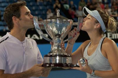 Roger Federer (L) and Belinda Bencic of Switzerland hoist the Hopman Cup after defeating Alexander Zverev and Angelique Kerber of Germany in the mixed doubles final on day eight of the Hopman Cup tennis tournament in Perth on January 6, 2018. / AFP PHOTO / TONY ASHBY / 