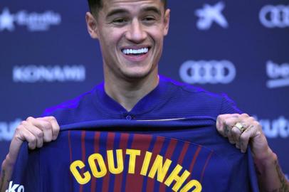 Barcelonas new Brazilian midfielder Philippe Coutinho shows his new jersey before holding a press conference in Barcelona on January 8, 2018. Philippe Coutinho officially joined Barcelona today, completing a move from Liverpool thought to be worth 160 million euros ($192 million), making it the third richest transfer in history. / AFP PHOTO / LLUIS GENE