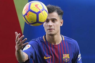 Barcelonas new Brazilian midfielder Philippe Coutinho plays with a ball as he poses with his new jersey during his official presentation in Barcelona on January 8, 2018. Philippe Coutinho officially joined Barcelona today, completing a move from Liverpool thought to be worth 160 million euros ($192 million), making it the third richest transfer in history. / AFP PHOTO / LLUIS GENE