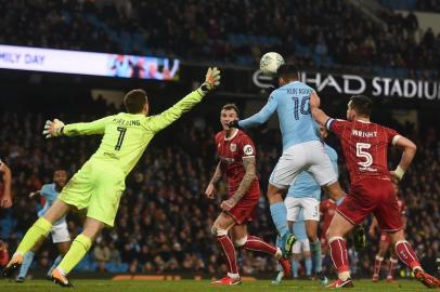 Manchester Citys Argentinian striker Sergio Aguero (C) jumps to score their late winning goal during the English League Cup semi-final first leg football match between Manchester City and Bristol City at the Etihad Stadium in Manchester, north west England, on January 9, 2018.Manchester City won the game 2-1. / AFP PHOTO / PAUL ELLIS / RESTRICTED TO EDITORIAL USE. No use with unauthorized audio, video, data, fixture lists, club/league logos or live services. Online in-match use limited to 75 images, no video emulation. No use in betting, games or single club/league/player publications.  / 