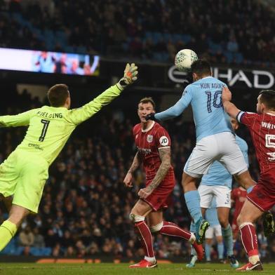 Manchester Citys Argentinian striker Sergio Aguero (C) jumps to score their late winning goal during the English League Cup semi-final first leg football match between Manchester City and Bristol City at the Etihad Stadium in Manchester, north west England, on January 9, 2018.Manchester City won the game 2-1. / AFP PHOTO / PAUL ELLIS / RESTRICTED TO EDITORIAL USE. No use with unauthorized audio, video, data, fixture lists, club/league logos or live services. Online in-match use limited to 75 images, no video emulation. No use in betting, games or single club/league/player publications.  / 