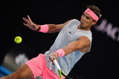  Spains Rafael Nadal hits a return against Dominican Republics Victor Estrella Burgos during their mens singles first round match on day one of the Australian Open tennis tournament in Melbourne on January 15, 2018. / AFP PHOTO / Greg Wood / -- IMAGE RESTRICTED TO EDITORIAL USE - STRICTLY NO COMMERCIAL USE --Editoria: SPOLocal: MelbourneIndexador: GREG WOODSecao: tennisFonte: AFPFotógrafo: STF