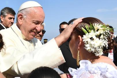 Pope Francis (L) greets people shortly after disembarking from his plane at the Peruvian city of Trujillo, and before heading to the beach resort town of Huanchaco where he will officiate an open-air mass on January 20, 2018.Pope Francis is set Saturday to hold a huge outdoor mass in a coastal region of Peru struggling to rebuild in the wake of devastating floods last year. / AFP PHOTO / Vincenzo PINTO