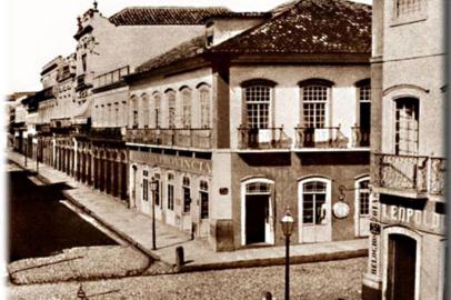 Primeira agência bancária do estado do Rio Grande do Sul funcionou neste sobrado que se situava na esquina da Rua dos Andradas com a Marechal Floriano. Foi inaugurada em 01 de julho de 1858. A fotografia foi tomada em 1875.