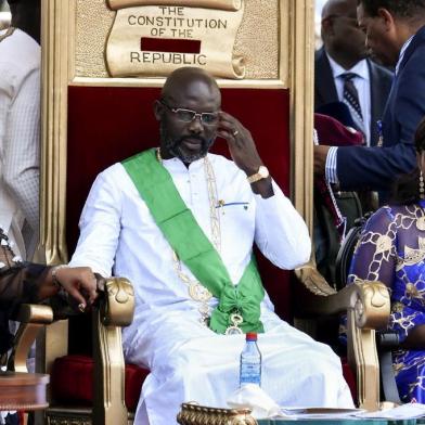  Liberias President-elect and former football star George Weah (C), his wife Clar Weah (R) and the countrys new Vice-President Jewel Taylor (L) attend Weahs swearing-in ceremony on January 22, 2018 in Monrovia.To the cheers of a crowd fired by his promise to bring them jobs and prosperity, former football star George Weah was sworn in as president of Liberia on January 22, completing the countrys first transition between democratically-elected leaders since 1944. / AFP PHOTO / ISSOUF SANOGOEditoria: POLLocal: MonroviaIndexador: ISSOUF SANOGOSecao: politics (general)Fonte: AFPFotógrafo: STF