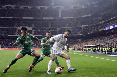 Real Madrids Spanish midfielder Isco (R) vies with Leganes Spanish defender Tito (C) and Leganes Spanish defender Unai Bustinza during the Spanish Copa del Rey (Kings cup) quarter-final second leg football match between Real Madrid CF and CD Leganes at the Santiago Bernabeu stadium in Madrid on January 24, 2018.  / AFP PHOTO / JAVIER SORIANO