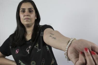  SANTA MARIA, RS, BRASIL - Tragédia da Kiss completa 05 anos no dia 27 de janeiro de 2018. Matéria especial sobre pessoas que perderam alguém na tragédia e tatuaram alguma coisa no corpo em homenagem. Na imagem JULIANA TORRES RIBEIRO, prima de FLÁVIA MARIA TORRES LEMOS. Ela tatuou trecho de música de Nando Reis no antebraço.Indexador: Jefferson Botega