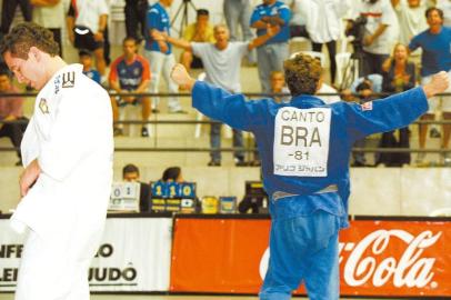 O meio-mÃ©dio carioca FlÃ¡vio Canto (deO meio-mÃ©dio carioca FlÃ¡vio Canto (de azul) comemora sua vitÃ³ria sobre Tiago Camilo na 1Ã£ etapa da seletiva olÃ­mpica de judÃ´ para os Jogos de Atenas, 2004, no bairro do Morumbi, em SÃ£o Paulo. (SÃ£o Paulo-SP, 21.12.2003. Foto de Daniel GuimarÃ£es/Folhapress. Negativo 200326878)Local: SP- SÃ£o Paulo ;SP- SÃ£o Paulo ;Bras