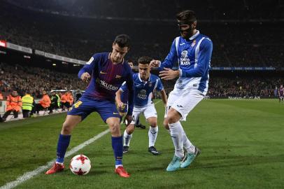 Barcelonas Brazilian midfielder Philippe Coutinho (L) challenges Espanyols Spanish midfielder David Lopez (R) and Espanyols Spanish midfielder Oscar Melendo (C) during the Spanish Copa del Rey (Kings cup) quarter-final second leg football match between FC Barcelona and RCD Espanyol at the Camp Nou stadium in Barcelona on January 25, 2018.  / AFP PHOTO / LLUIS GENE