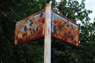  CAXIAS DO SUL, RS, BRASIL (15/01/2018). Cidadania Zero no Meio Ambiente Urbano. Administração pública displicente, combinada com más atitudes de cidadãos, colabora para degradar o meio ambiente nas calaçadas, lixo na rua, placas destruídas e sem a grafia, acesso para cadeirante interrompido, etc.  Contra do Pioneiro. NA FOTO,  NA  RUA ABILIO WEBWER, BAIRRO MARECHAL FLORIANO,  PLACA DE LOCALIZAÇÃO DA RUA ESTÁ ENFERRUJADA.  (Roni Rigon/Pioneiro).