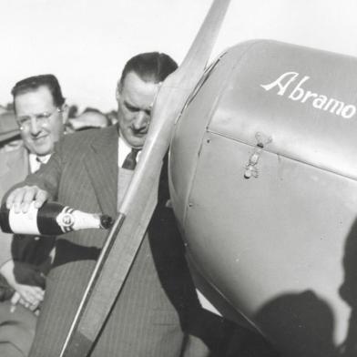 Inauguração do Aeroclube de Caxias do Sul. Da inauguração participou o empresário Assis Chateaubriand. Na foto vemos o prefeito Dante Marcucci batizando com champanhe o avião do empresário Abramo Eberle. Ao fundo, Júlio João Eberle e o ministro da aeronáutica Joaquim Pedro Salgado Filho.