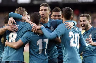 Real Madrids Portuguese forward Cristiano Ronaldo (C) and teammates celebrate Real Madrids German midfielder Toni Kroos goal (2L) during the Spanish league football match between Valencia CF and Real Madrid CF at the Mestalla stadium in Valencia on January 27, 2018. / AFP PHOTO / JOSE JORDAN