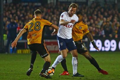 Tottenham Hotspurs English striker Harry Kane (C) vies with Newport Countys English defender Mickey Demetriou (L) and Newport Countys English midfielder Joss Labadie (R) during the English FA Cup fourth round football match between Newport County and Tottenham Hotspur at Rodney Parade in Newport, in south Wales, on January 27, 2018. / AFP PHOTO / Geoff CADDICK / RESTRICTED TO EDITORIAL USE. No use with unauthorized audio, video, data, fixture lists, club/league logos or live services. Online in-match use limited to 75 images, no video emulation. No use in betting, games or single club/league/player publications.  / 