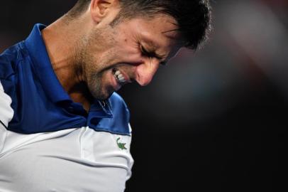 Serbias Novak Djokovic reacts during their mens singles fourth round match against South Koreas Hyeon Chung on day eight of the Australian Open tennis tournament in Melbourne on January 22, 2018. / AFP PHOTO / Paul Crock / -- IMAGE RESTRICTED TO EDITORIAL USE - STRICTLY NO COMMERCIAL USE --