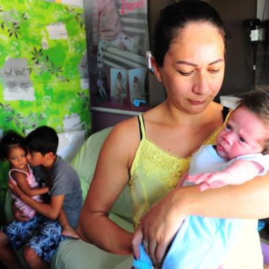  CAXIAS DO SUL, RS, BRASIL, 31/01/2018. Jane da Silva Viegas, 34 anos, é moradora do bairro século XX. A UBS do bairro está sem especialista desde novembro e ela precisa levar os filhos e o neto no postinho do Diamantino. A prefeitura não tem previsão de quando vai repor a vaga de pediatra. Na foto, Na foto, Jane segura o neto Lorenzo, um mês, o filho Wesley, 11 anos e a filha Lavínia, 1 anos. (Porthus Junior/Agência RBS)