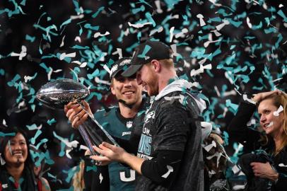 Super Bowl LII - Philadelphia Eagles v New England PatriotsQuarterbacks Nick Foles (L) and Carson Wentz (R) of the Philadelphia Eagles celebrates following victory over the New England Patriots in  Super Bowl LII at US Bank Stadium in Minneapolis, Minnesota, on February 4, 2018.The Philadelphia Eagles scored a stunning 41-33 upset victory over the New England Patriots to win their first ever Super Bowl after a costly Tom Brady fumble ended the quarterbacks tilt at history. Foles was a back-up who was thrust into the starting position when Carson Wentz suffered a season-ending injury in December. / AFP PHOTO / TIMOTHY A. CLARYEditoria: SPOLocal: MinneapolisIndexador: TIMOTHY A. CLARYSecao: American footballFonte: AFPFotógrafo: STF