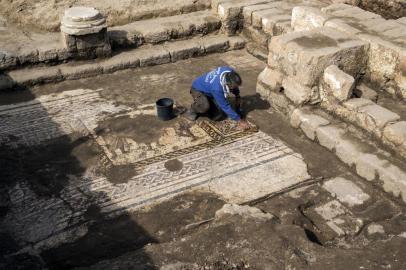  Workers from the Israeli Antiquity Authority (IAA) clean a rare Roman mosaic from the 2nd–3rd centuries at the Israeli Caesarea National Park on February 8, 2018.According to Dr. Peter Gendelman and Dr. Uzi Ad, directors of the excavation for the IAA: This colourful mosaic, measuring more than 3.5 x 8 meters, is of a rare high quality. It features three figures, multicoloured geometric patterns and a long inscription in Greek. / AFP PHOTO / JACK GUEZEditoria: ACELocal: CaesareaIndexador: JACK GUEZSecao: archaeologyFonte: AFPFotógrafo: STF