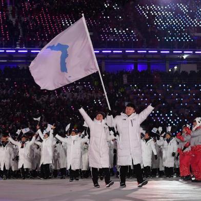 Unified Koreas flagbearers (North Koreas ice hockey player) Hwang Chung Gum (L) and (South Koreas bobsledder) Won Yun-jong (R) lead the Unified Koreas delegation as they parade during the opening ceremony of the Pyeongchang 2018 Winter Olympic Games at the Pyeongchang Stadium on February 9, 2018.  / AFP PHOTO / Mark RALSTON