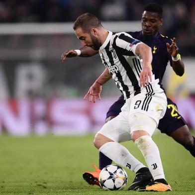 Juventus forward from Argentina Gonzalo Higuain (L) fights for the ball with Tottenham Hotspurs Ivorian defender Serge Aurier during the UEFA Champions League round of sixteen first leg football match between Juventus and Tottenham Hotspur at The Allianz Stadium in Turin on February 13, 2018.  / AFP PHOTO / Marco BERTORELLO