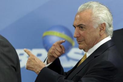  Brazilian President Michel Temer gestures during the signature of a decree to send in the army to lead public safety in Rio de Janeiro state, at the Planalto Palace in Brasilia, on February 16, 2018.Army patrols are already used in Rios favelas ruled by drug gangs, but the decree will now give the military full control of security operations in Rio state, which the president said had virtually been seized by organized crime gangs. / AFP PHOTO / Sergio LIMAEditoria: POLLocal: BrasíliaIndexador: SERGIO LIMASecao: armed ForcesFonte: AFPFotógrafo: STR