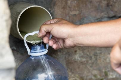  People collect drinking water from pipes fed by an underground spring, in St. James, about 25km from the city centre, on January 19, 2018, in Cape Town.Cape Town will next month slash its individual daily water consumption limit by 40 percent to 50 litres, the mayor said on January 18, as the city battles its worst drought in a century. / AFP PHOTO / RODGER BOSCHEditoria: POLLocal: Le CapIndexador: RODGER BOSCHSecao: droughtFonte: AFPFotógrafo: STR