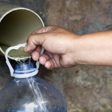  People collect drinking water from pipes fed by an underground spring, in St. James, about 25km from the city centre, on January 19, 2018, in Cape Town.Cape Town will next month slash its individual daily water consumption limit by 40 percent to 50 litres, the mayor said on January 18, as the city battles its worst drought in a century. / AFP PHOTO / RODGER BOSCHEditoria: POLLocal: Le CapIndexador: RODGER BOSCHSecao: droughtFonte: AFPFotógrafo: STR