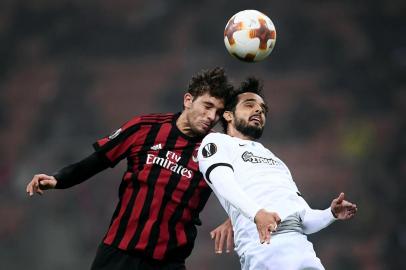 AC Milans midfielder Manuel Locatelli (L) fights for the ball with AEKs defender Helder Lopes from Portugal during the UEFA Europa League football match AC Milan vs AEK Athens at the San Siro Stadium in Milan on October 19, 2017.  / AFP PHOTO / MARCO BERTORELLO