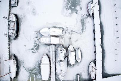  Picture taken with a drone shows snow-covered sailing ships mooring at the boatyard harbour of Kirchdorf on the Baltic Sea island of Poel, northeastern Germany, where bays risk to freeze due to permafrost and night temperatures below minus ten degrees Celsius, on February 27, 2018.A blast of Siberian weather dubbed The Beast from the East sent temperatures plunging across much of Europe. / AFP PHOTO / dpa / Jens Büttner / Germany OUTEditoria: WEALocal: KirchdorfIndexador: JENS BUTTNERSecao: reportFonte: dpaFotógrafo: STR