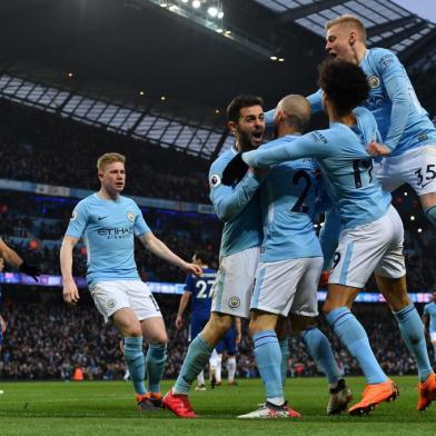 Manchester Citys Portuguese midfielder Bernardo Silva (C) celebrates with tammates scoring the opening goal during the English Premier League football match between Manchester City and Chelsea at the Etihad Stadium in Manchester, north west England on March 4, 2018. / AFP PHOTO / Anthony Devlin / RESTRICTED TO EDITORIAL USE. No use with unauthorized audio, video, data, fixture lists, club/league logos or live services. Online in-match use limited to 75 images, no video emulation. No use in betting, games or single club/league/player publications.  / 