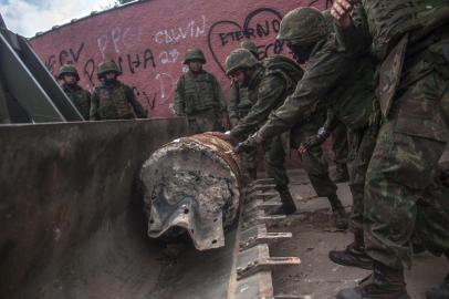  Soldiers of the Armed Forces, backed by armoured vehicles, aircraft and heavy engineering equipment, clear a road blockade as they take part in an operation in the violence-plagued favela of Vila Kennedy, in Rio de Janeiro, Brazil, on March 7, 2018.The Brazilian army launched a new operation on a favela in Rio de Janeiro, the third since President Michel Temer ordered the military to take over the command of security in the whole of Rio state to fight organized crime. / AFP PHOTO / Mauro PIMENTELEditoria: POLLocal: Rio de JaneiroIndexador: MAURO PIMENTELSecao: security measuresFonte: AFPFotógrafo: STF