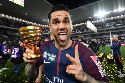 Paris Saint-Germains Brazilian defender Daniel Alves holds the trophy as he celebrates after victory in the French League Cup final football match between Monaco (ASM) and Paris Saint-Germain (PSG) at The Matmut Atlantique Stadium in Bordeaux, southwestern France on March 31, 2018.  / AFP PHOTO / FRANCK FIFE