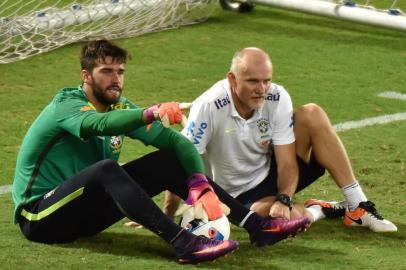 Brazil's football goalkeeper coach Claudio Taffarel sits next to  Brazil's goalkeeper Alisson during a training session at the Arena Dunas stadium in Natal, Brazil on October 8, 2016 ahead of a 2018 FIFA Russia World Cup qualifier match against Venezuela on October 11 in Merida, Venezuela.  / AFP PHOTO / NELSON ALMEIDA