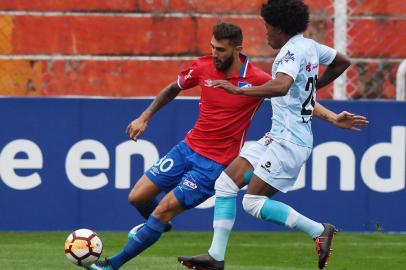 Uruguays Nacional player Gino Peruzzi (L) vies for the ball with Perus Real Garcilaso player Julio Landauri, during their Copa Libertadores football match at the Garcilaso Stadium in the Andean city of Cusco, Peru on April 3, 2018. / AFP PHOTO / CRIS BOURONCLE